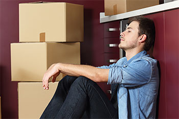 Man feeling the stress of moving out after a breakup