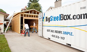 Building a garage with a storage container in the driveway